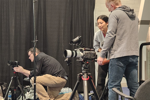 Photo of three people setting up video cameras